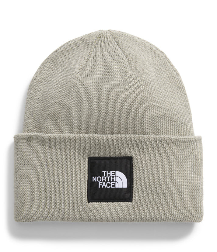 Grey knit beanie with a black square patch that says "THE NORTH FACE" in white text above a white logo.