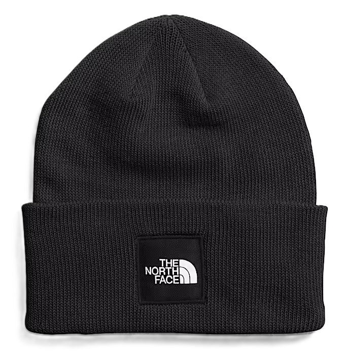 Black knit beanie with a rectangular patch. The patch has the words "THE NORTH FACE" above a graphic.