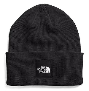 Black knit beanie with a rectangular patch. The patch has the words "THE NORTH FACE" above a graphic.