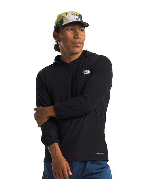 A man wearing a black hooded long sleeve shirt with a small white logo on the chest and a colorful floral baseball cap.