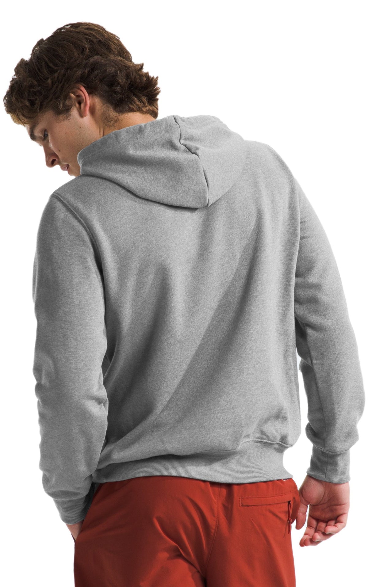 Man wearing a gray hooded sweatshirt and red pants from the back.