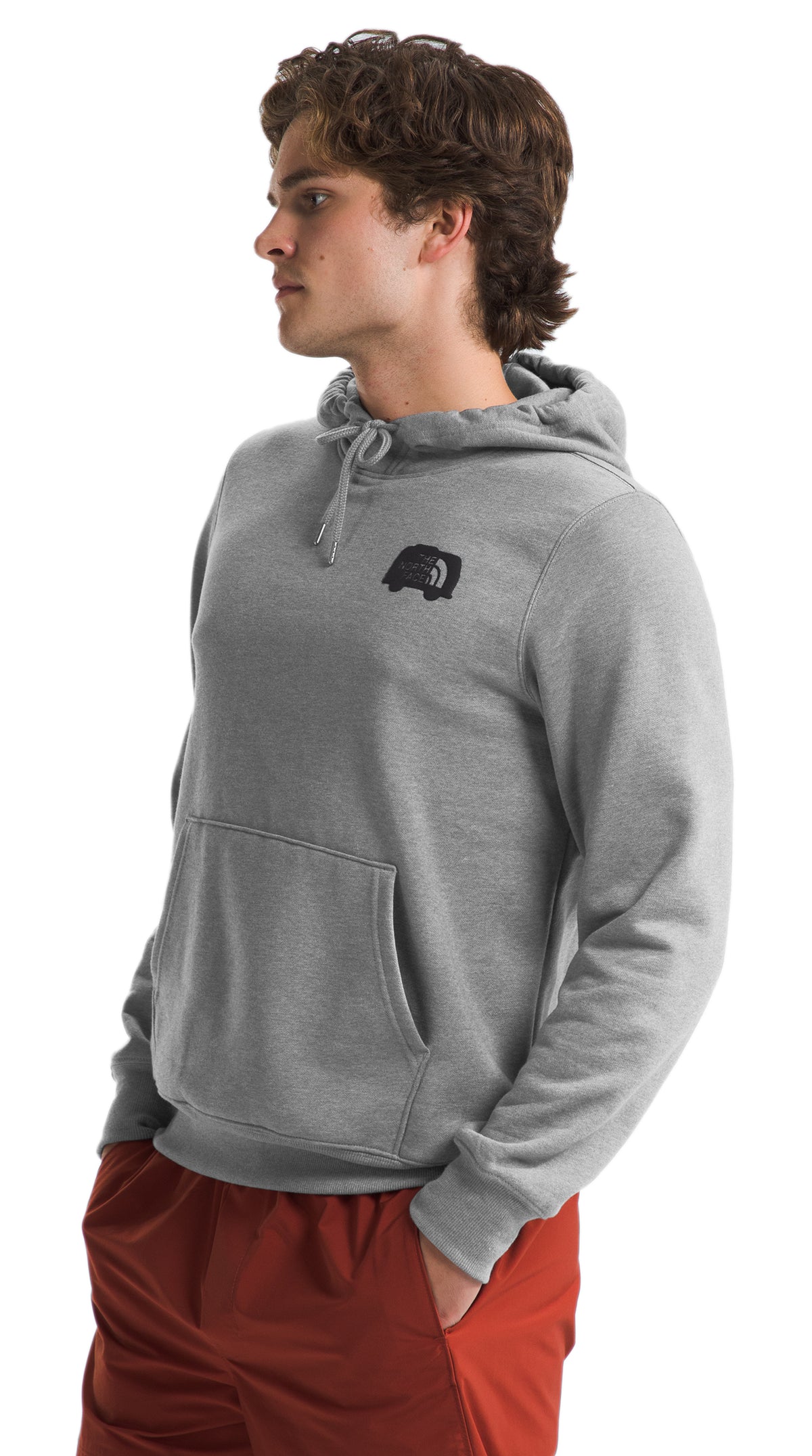 A man wearing a gray hoodie and red pants.