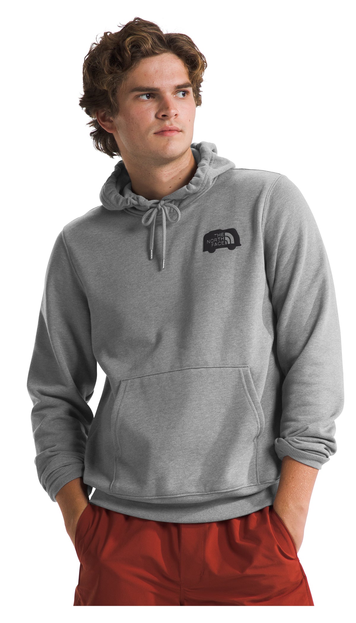 Man wearing a gray hoodie with a chest logo and a kangaroo pocket, paired with red pants.