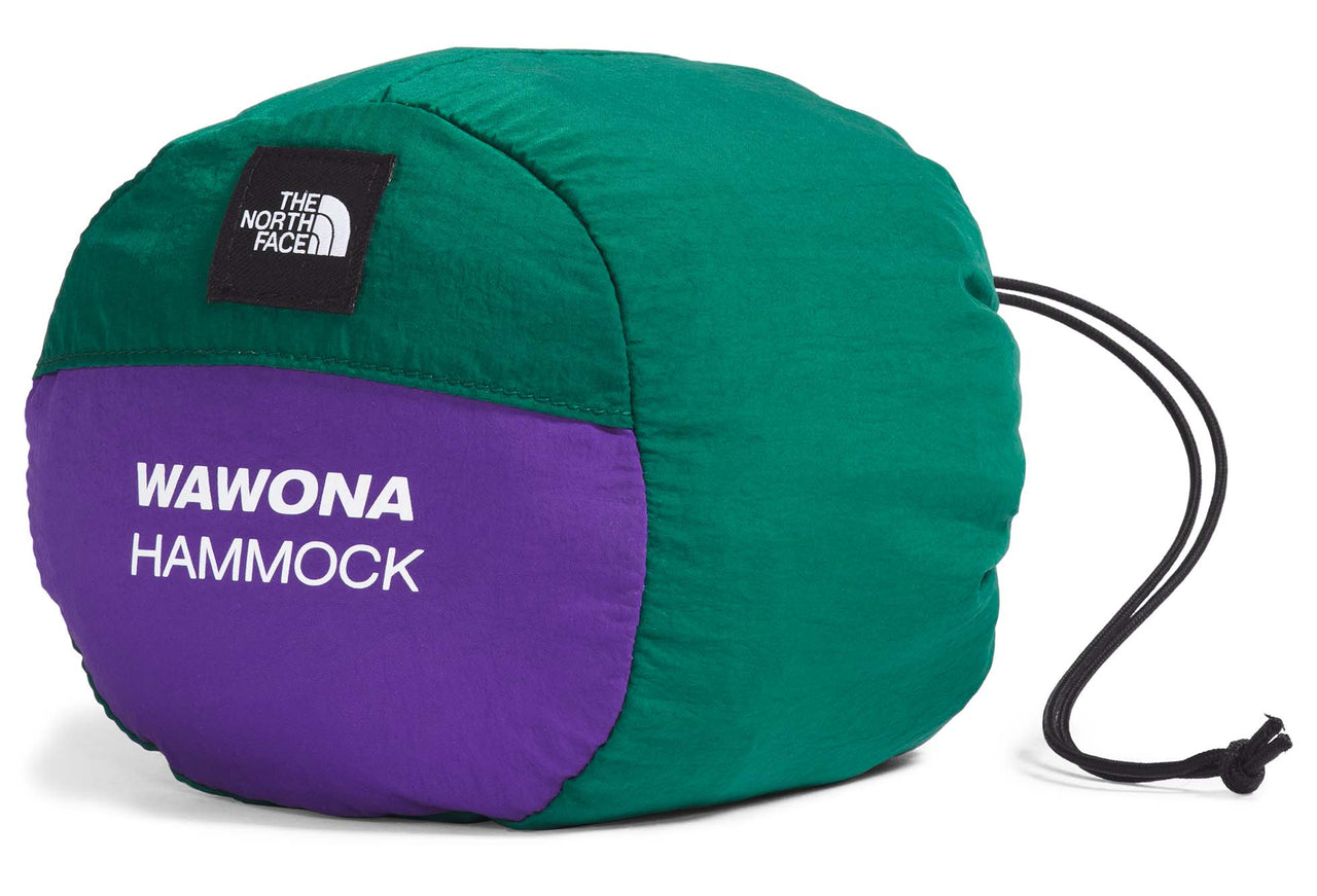 Green and purple stuff sack with a black logo square and white text that says "WAWONA HAMMOCK"