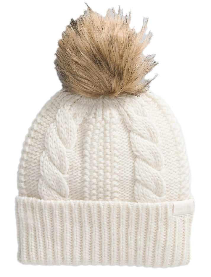 Cream-colored knit beanie with faux-fur pompom and cable stitch detailing.