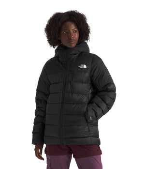 A woman wearing a black, hooded, insulated jacket.