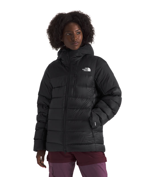 A woman wearing a black, hooded, insulated jacket.