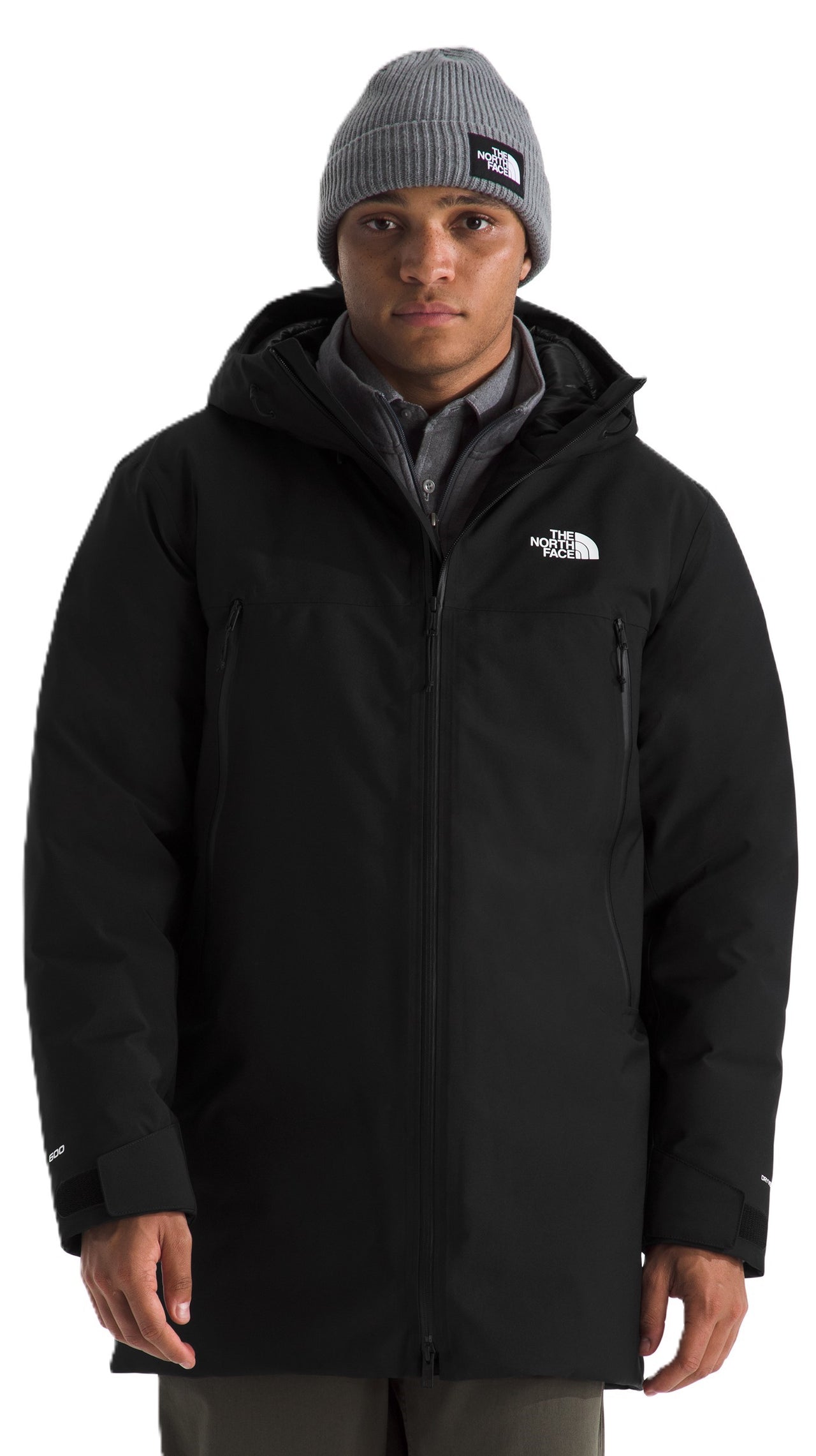 A man wearing a grey beanie and a long-sleeved black jacket with a hood.