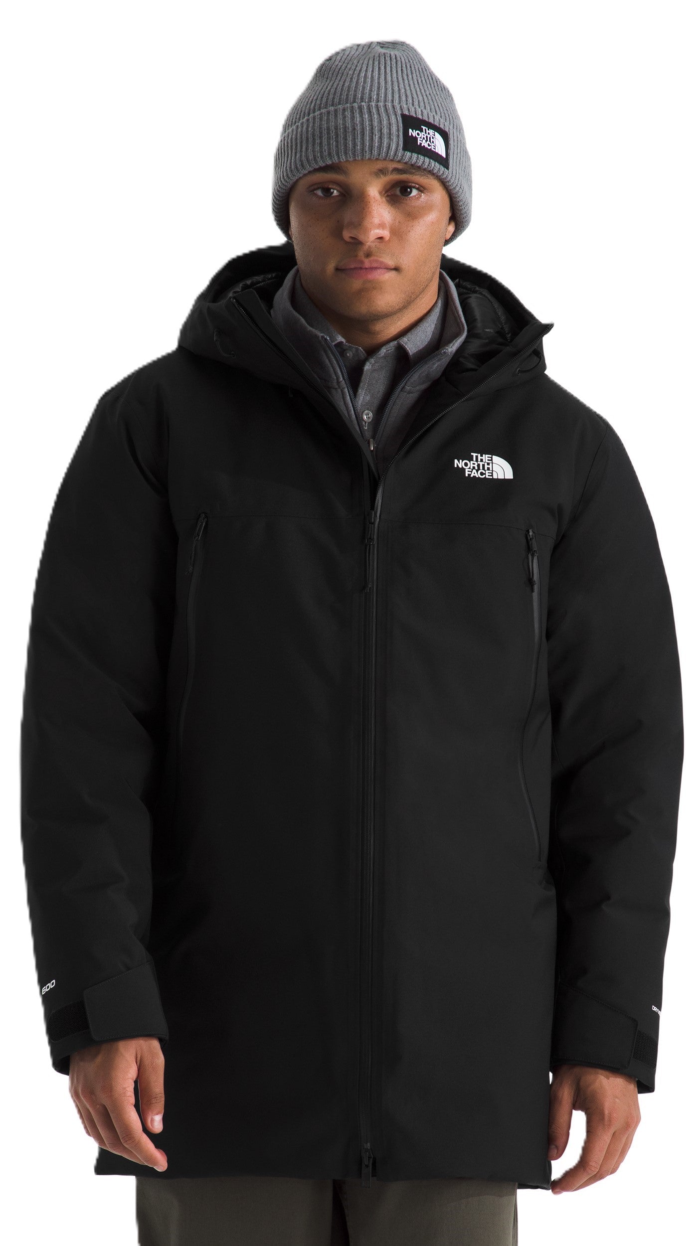 A man wearing a grey beanie and a long-sleeved black jacket with a hood.