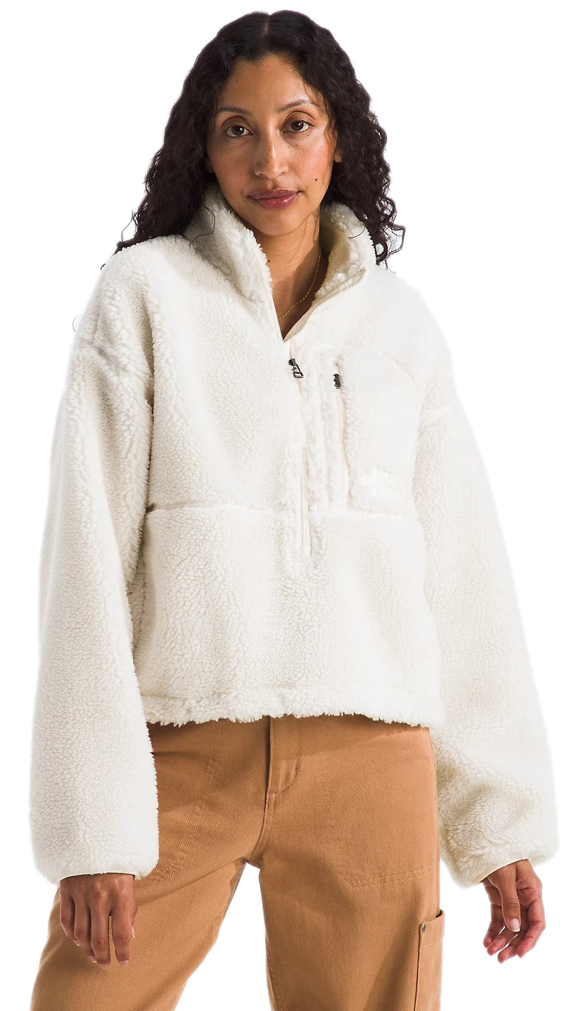 A light-skinned woman wearing a cream-colored, half-zip, sherpa fleece jacket and tan pants.