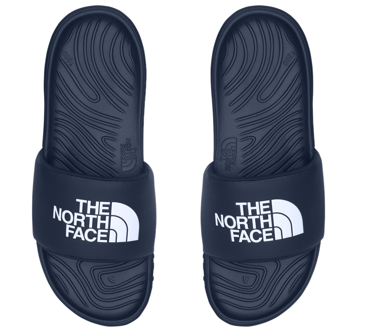 Top-down view of a pair of dark blue slide sandals, each with white "THE NORTH FACE" text on the upper band.
