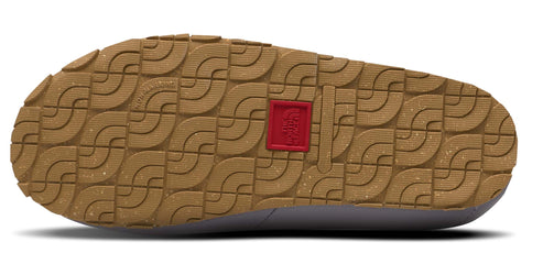 The sole of a shoe shows a textured brown pattern and a red square.