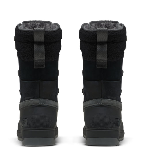A pair of black, mid-calf height boots with grey accents and padded trim, viewed from the back.
