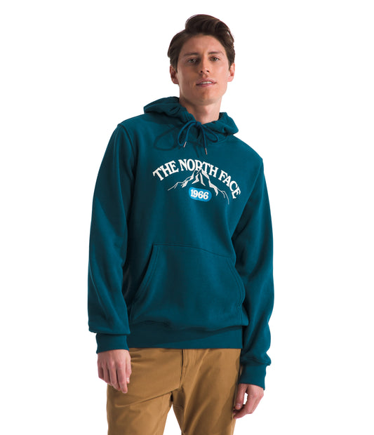 A person wearing a teal hoodie with "The North Face 1966" printed on it.