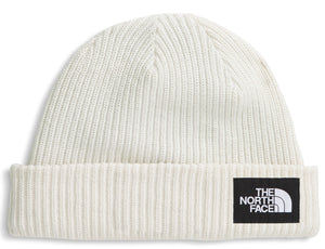 Close-fitting off-white knit hat with a black rectangular patch displaying the words 'THE NORTH FACE' stacked above a quarter circle shape.