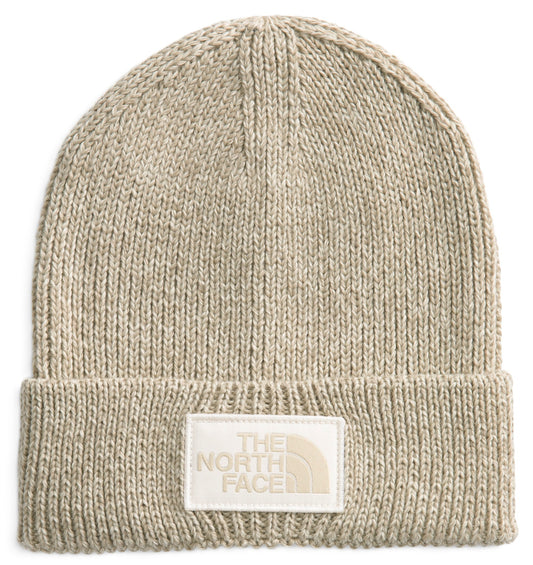 Knitted beige beanie with white rectangular patch with "THE NORTH FACE" lettering.
