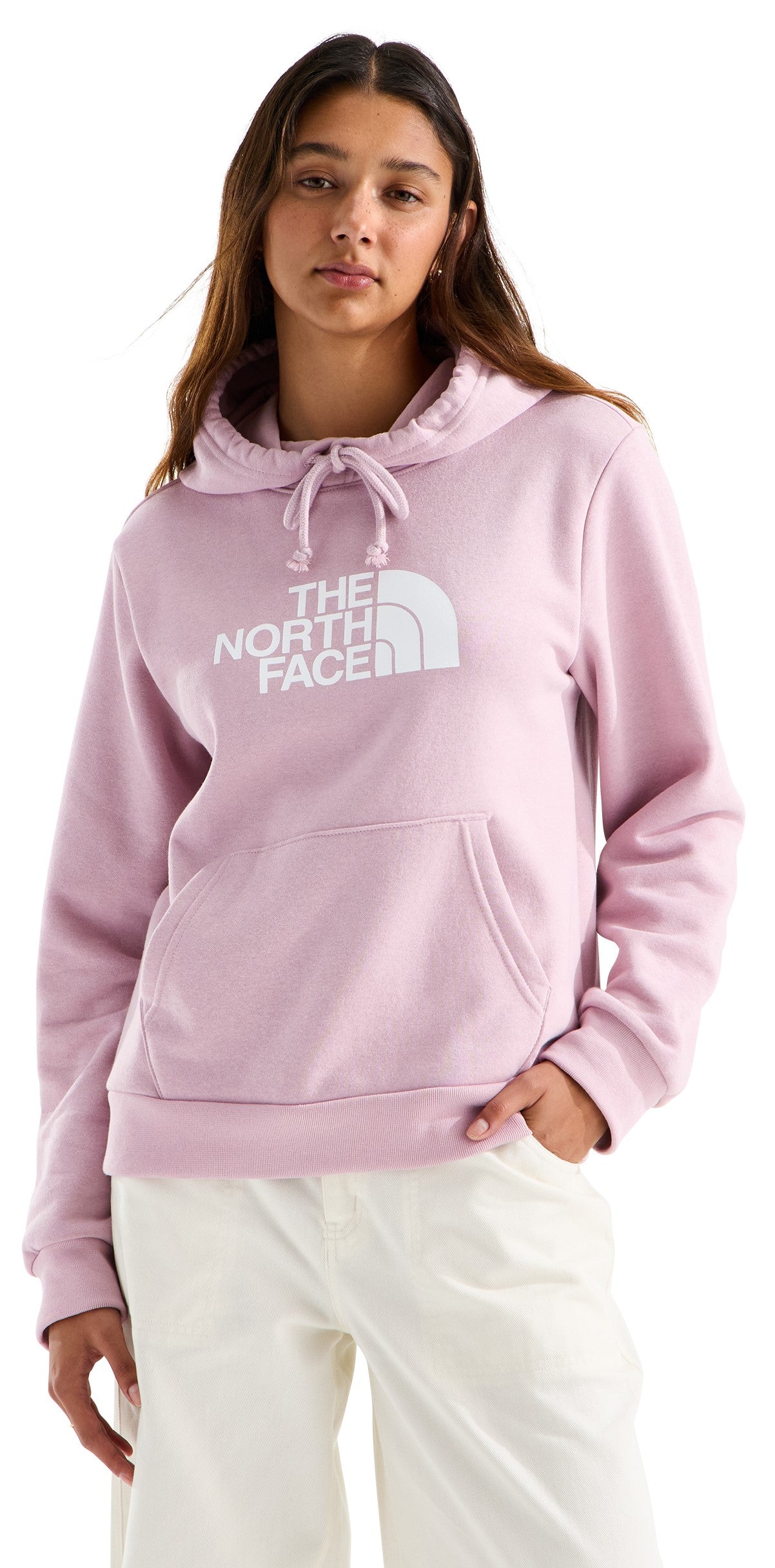 A light pink pullover hoodie featuring a white printed brand logo on the chest, a drawstring hood, and a front kangaroo pocket, worn by a woman.