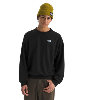 A person wearing a black long-sleeved shirt and a mustard colored knit hat.