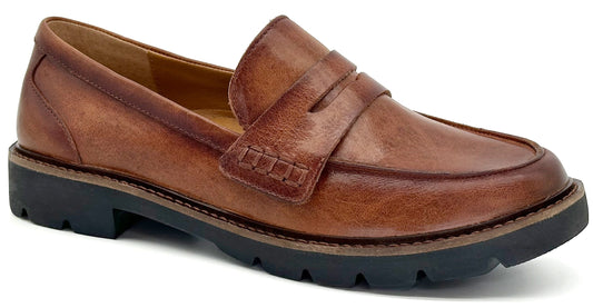 A brown leather penny loafer with a thick black lug sole against a plain background.