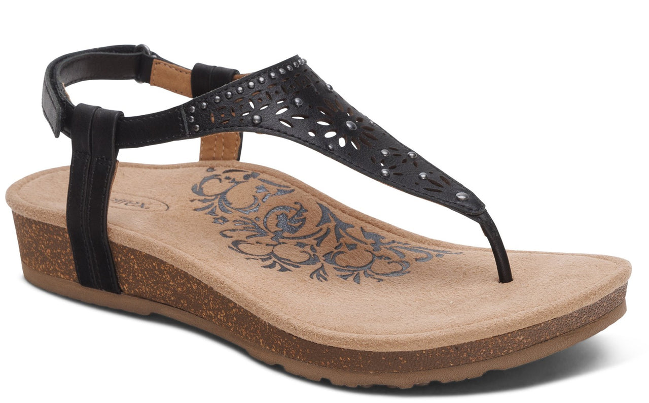 Black thong sandal with ankle strap and decorative cutouts.