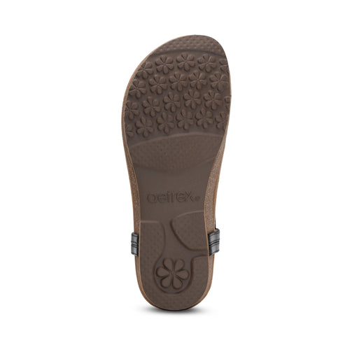 Brown sandal sole with daisy patterned tread.