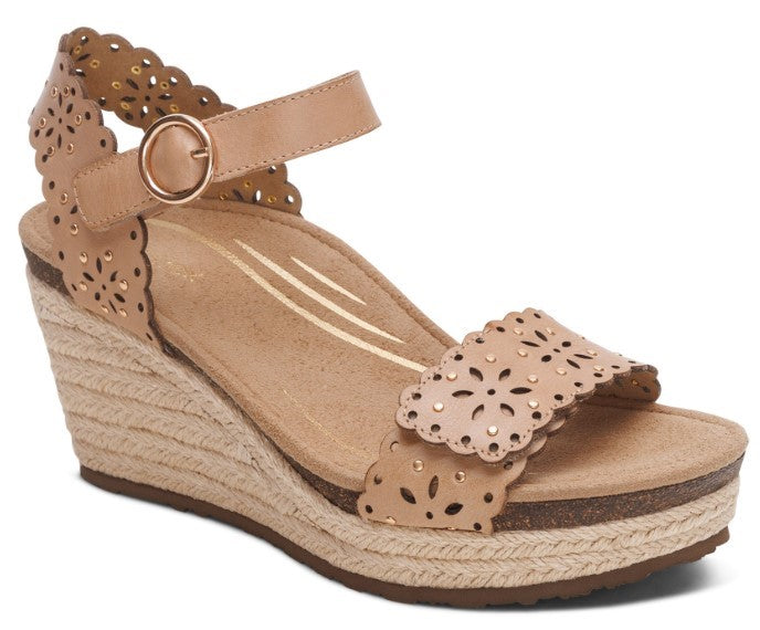 Tan wedge sandal with laser-cut floral design and ankle strap.