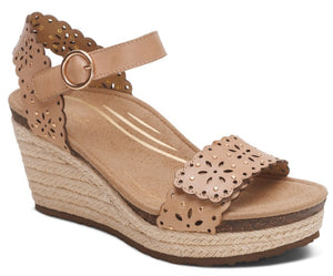 Tan wedge sandal with laser-cut floral design and ankle strap.