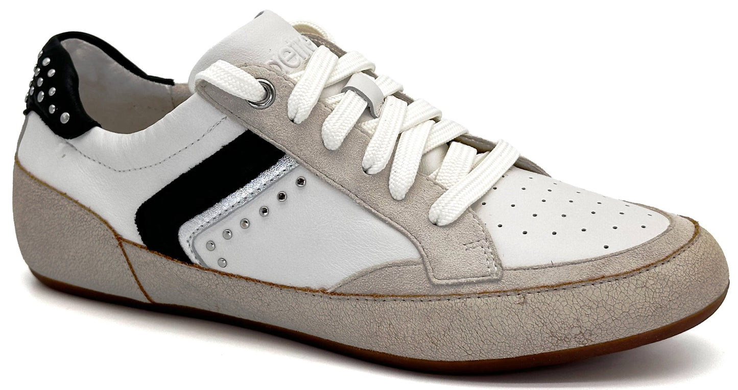 A low-top sneaker with a white leather upper, grey suede overlays at the toe and heel, a black stripe accent, silver studs on the heel and side, and white laces against a plain white background.
