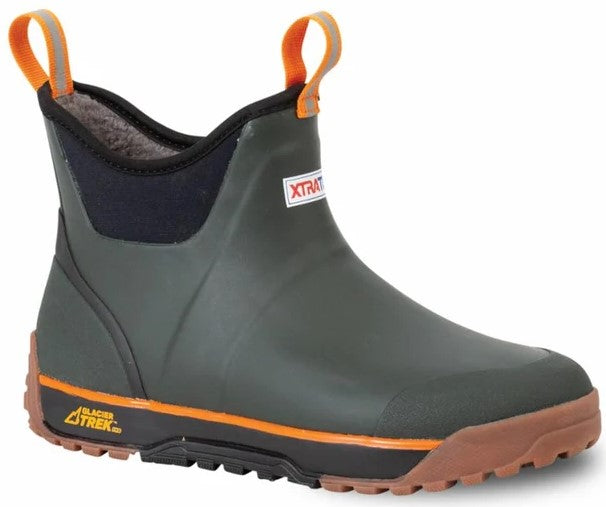 A slip-on ankle boot with an olive green rubber upper, a black neoprene collar, and a thick, chunky brown and black textured rubber sole. The boot features bright orange pull tabs at the front and back, and an orange accent strip above the sole, with 'XTRATUF' visible on a white tag and 'GLACIER TREK PRO' printed in gold near the heel.