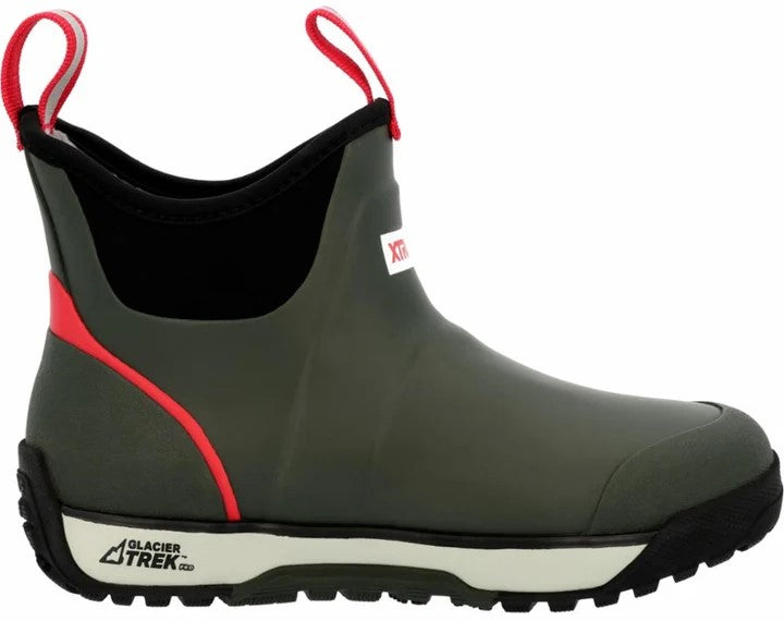 An olive green ankle-height waterproof rubber boot with a black collar, bright red accents, dual red pull tabs, and a cream-colored midsole with a black, rugged outsole, featuring the text "GLACIER TREK" printed on the side of the heel.