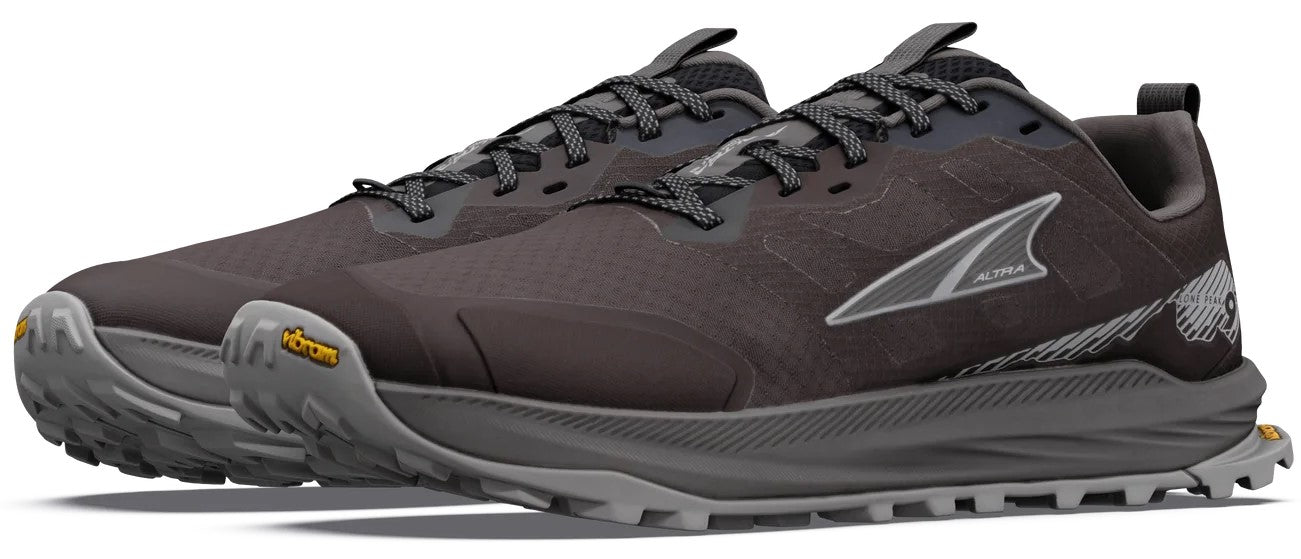 A pair of charcoal-colored trail running shoes with a thick grey sole, Vibram tread, laces, and the brand name Altra printed on the side.