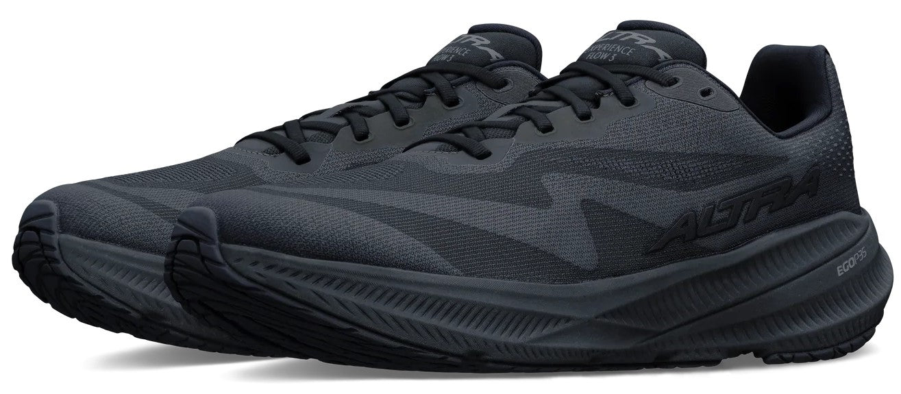 A pair of black Altra Experience Form running shoes with black laces, a mesh upper, and a thick, textured black midsole, shown from a three-quarter angle.