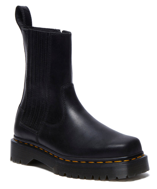 Black leather Chelsea boot with yellow stitching and a thick platform sole.