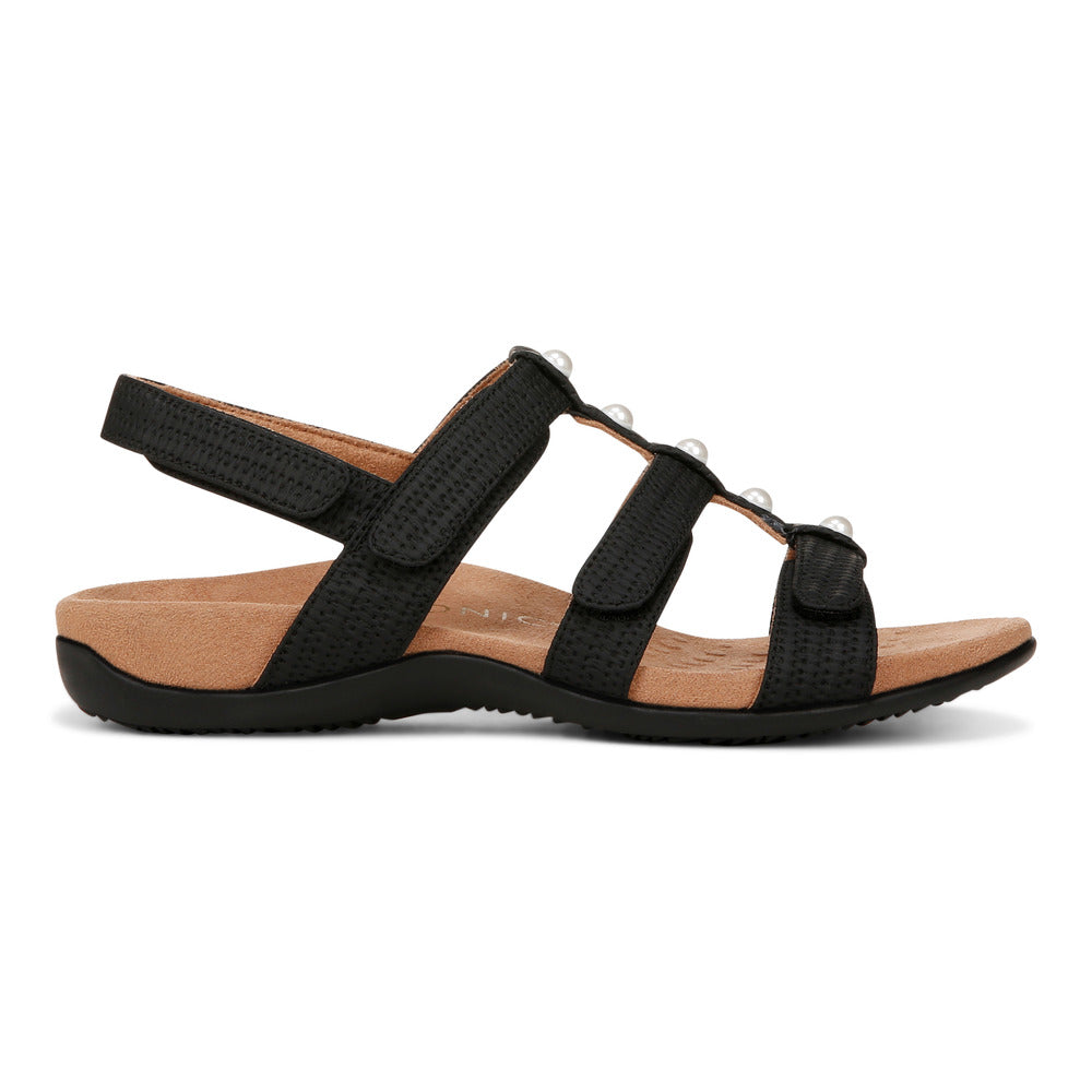 Black sandal with tan sole and three hook and loop straps with decorative accents.
