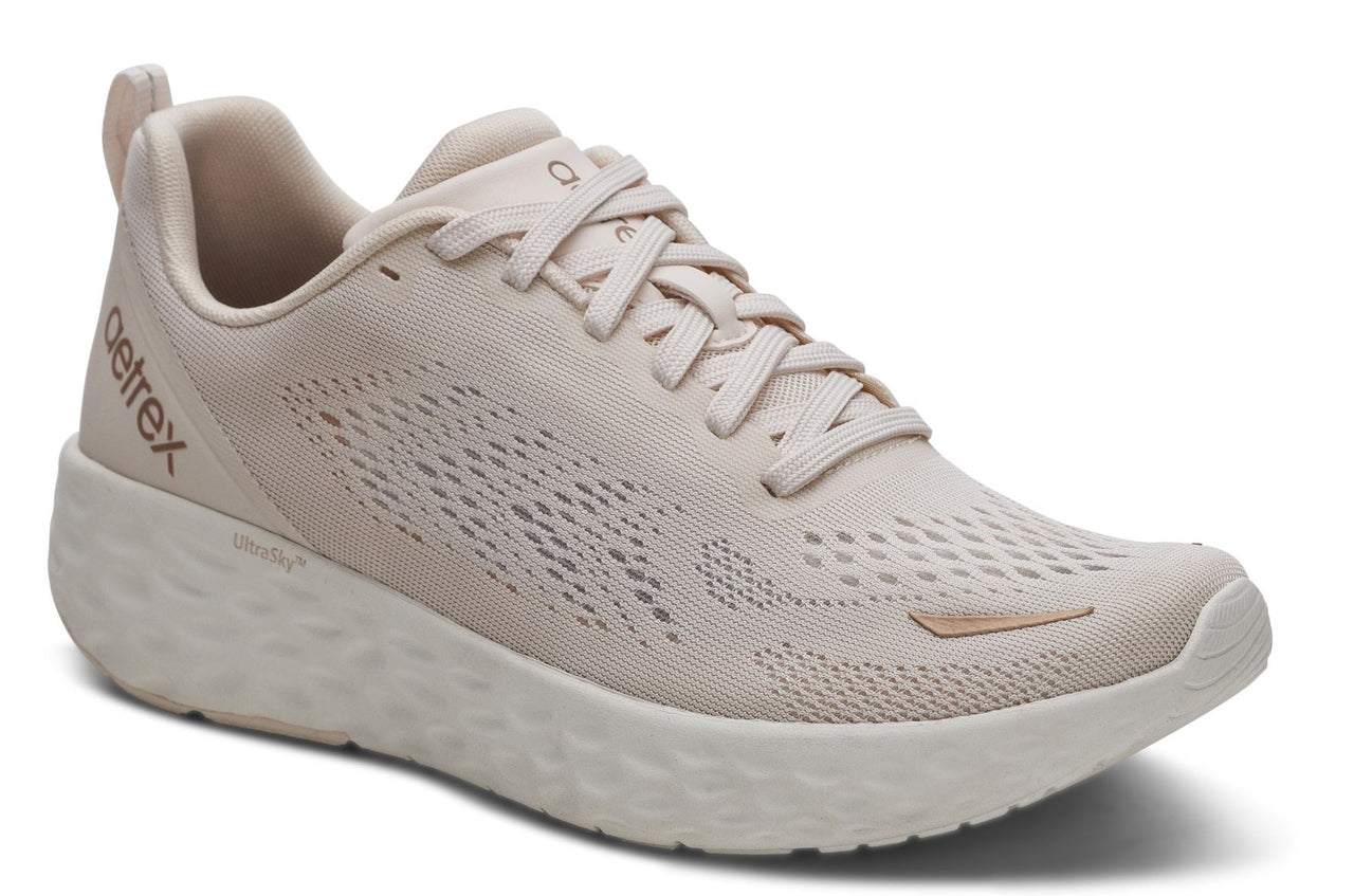 A light beige running shoe with breathable mesh and thick sole.