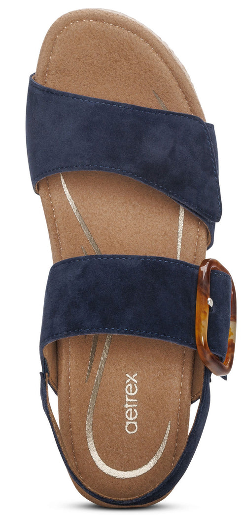 A pair of blue open-toed sandals with a brown tortoise-shell buckle.