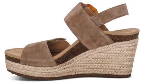 Side view of a taupe suede wedge sandal with espadrille-style trim.