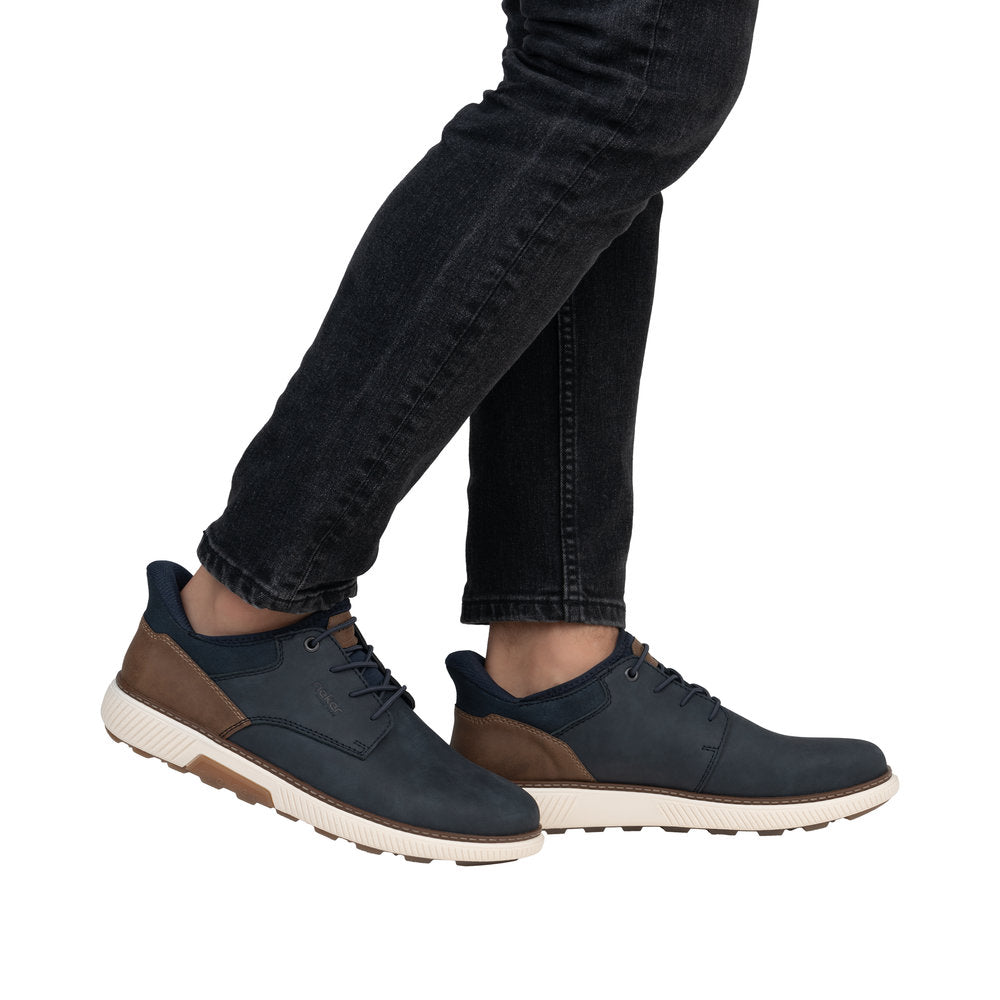 Person wearing navy blue casual leather shoes with white textured soles.