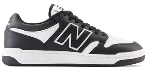 A low-top athletic shoe with black and white coloring and a New Balance logo on the side.