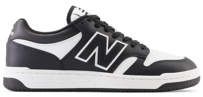 A low-top athletic shoe with black and white coloring and a New Balance logo on the side.