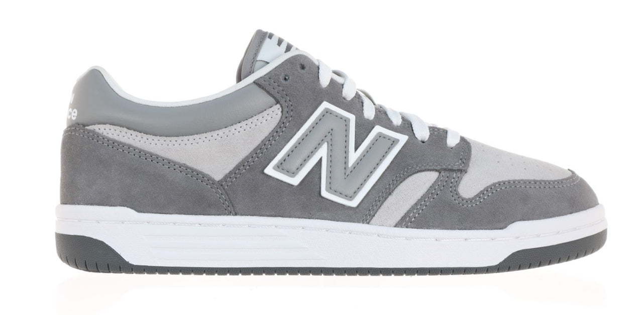 A gray sneaker with a white sole and 'N' logo.