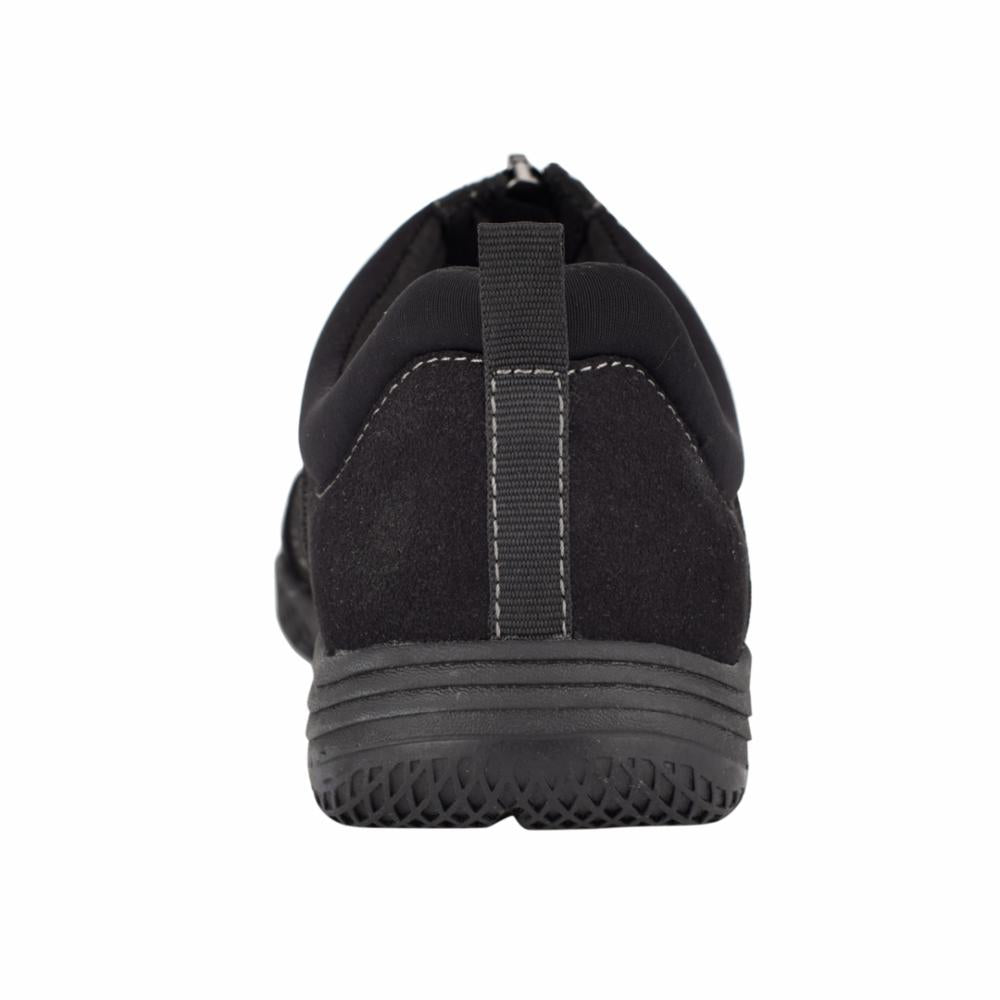 Black slip-on shoe with textured sole, viewed from the back.