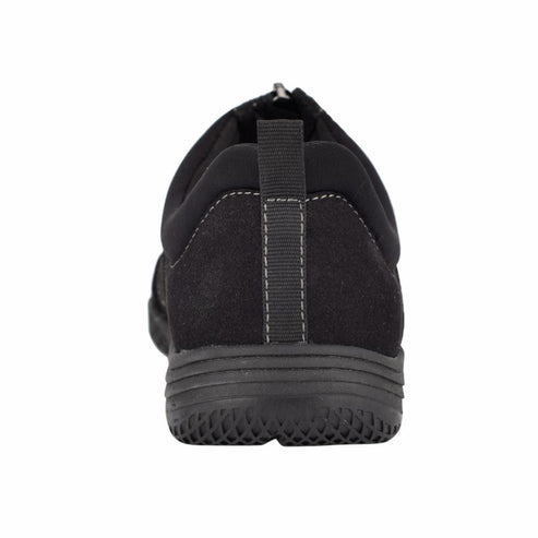 Black slip-on shoe with textured sole, viewed from the back.