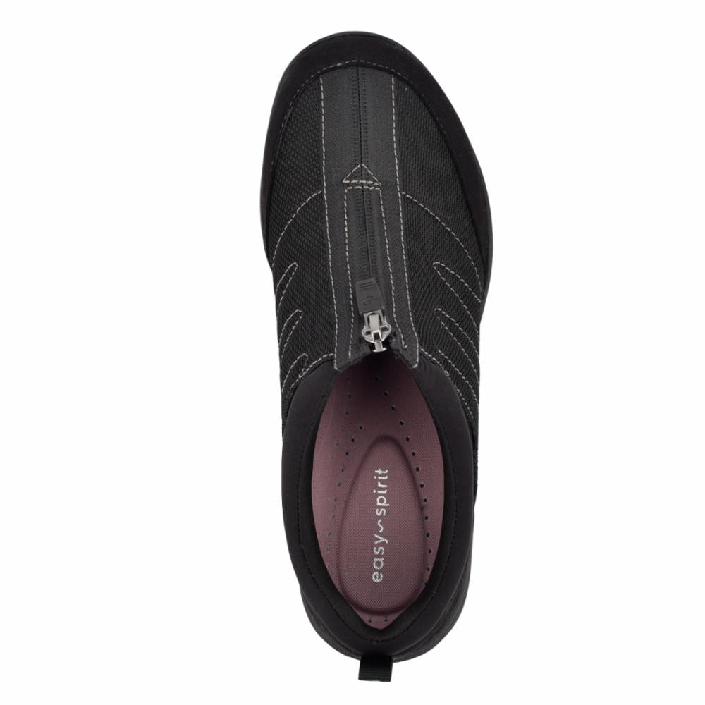 Top-down view of a black slip-on shoe with a central zipper, and a light pink insole visible.