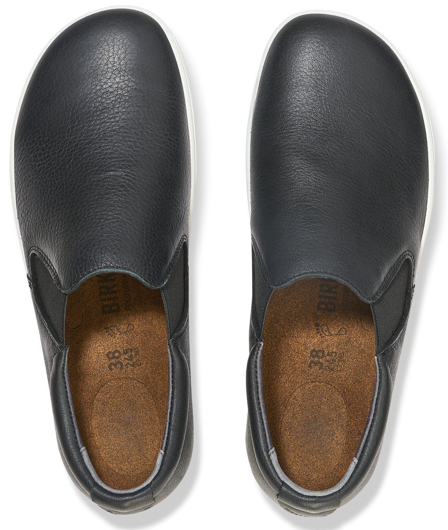 A pair of black leather slip-on shoes with cork insoles, viewed from directly above, showing size 38 stamped on the interior.