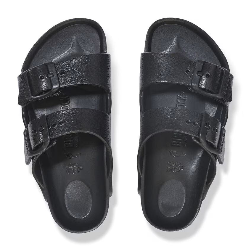 Overhead view of two black, two-strap, adjustable-buckle sandals.