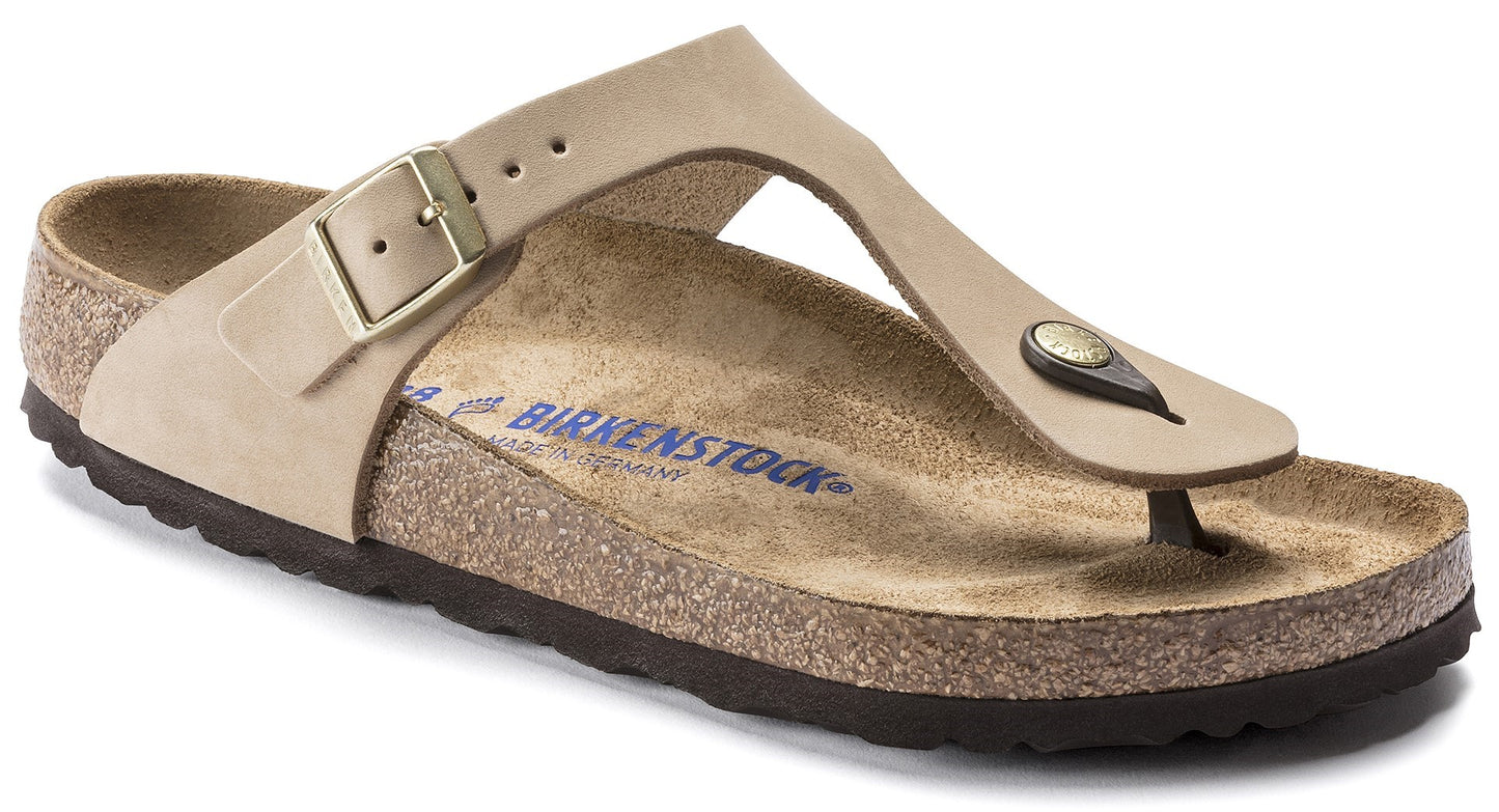 Tan T-strap sandal with adjustable buckle and cork footbed.