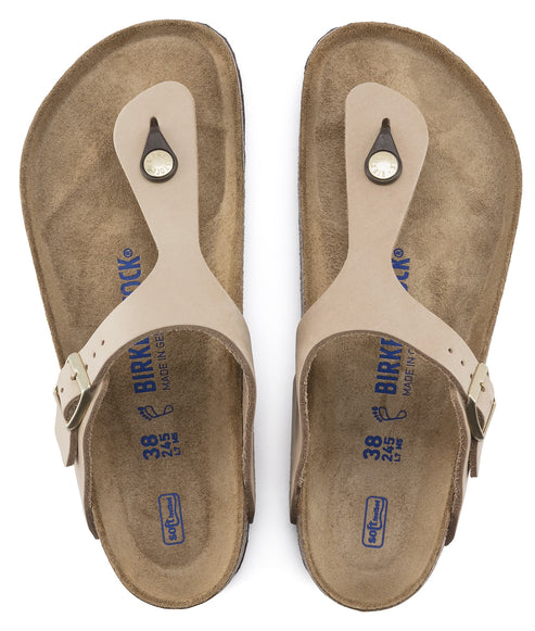 Pair of beige thong sandals with an adjustable strap.
