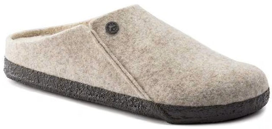 A light beige felt slip-on mule with a dark brown, textured cork-like sole and a small branded button on the side.