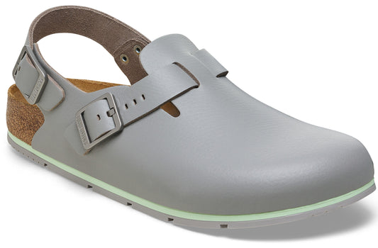 A light grey, closed-toe sandal made of smooth material, featuring a back strap with a metal buckle, a side strap with a metal buckle, a cork-style heel cup, and a pale green trim along the edge of the sole.